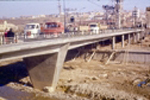 Vista de un lateral del puente con gente y vehículos sobre el puente "B"