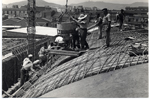 Detalle de construcción, obreros trabajando en el techado de la escuela