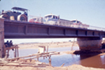 Vista paso de camiones y maquinaria sobre el puente en construcción